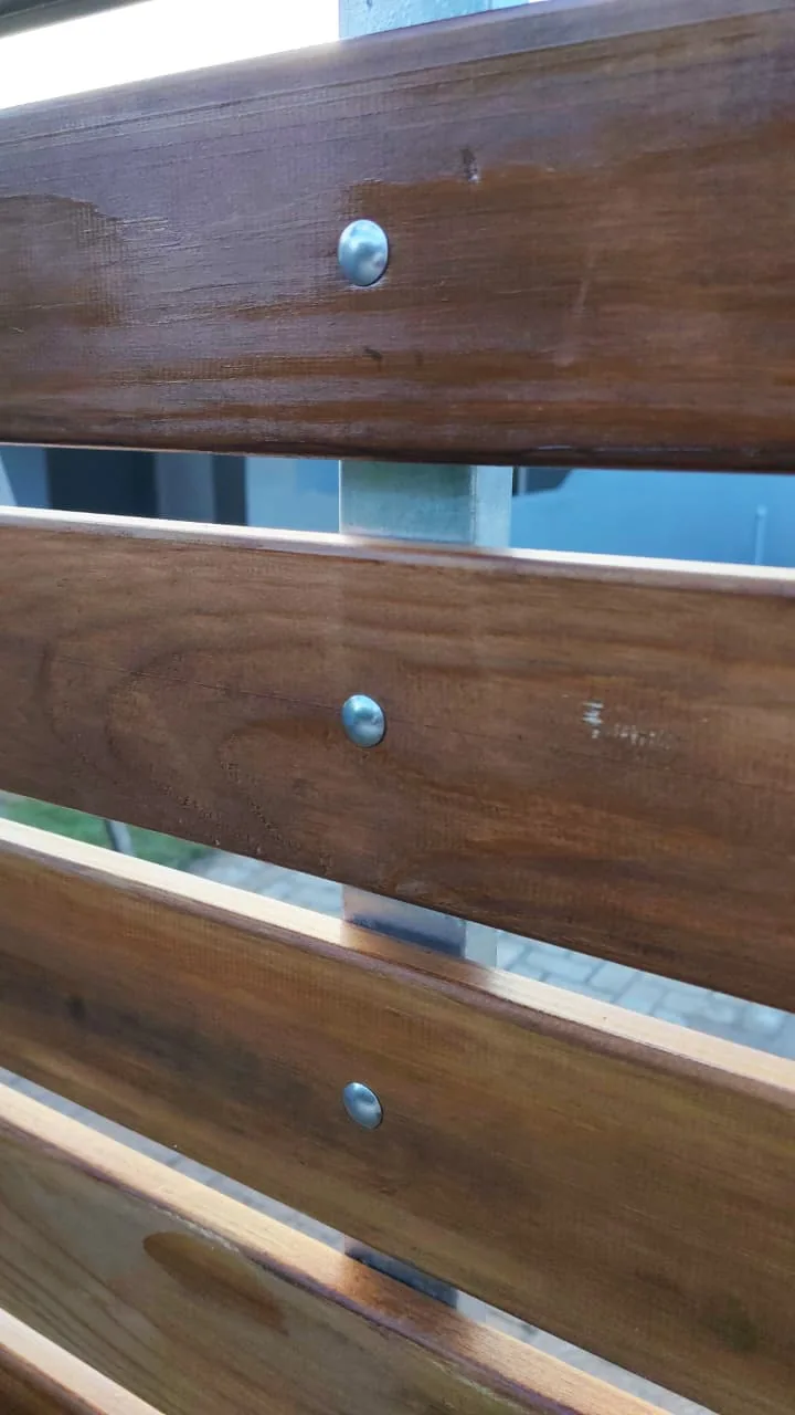 Close-up of timber-look gate slats and metal fasteners